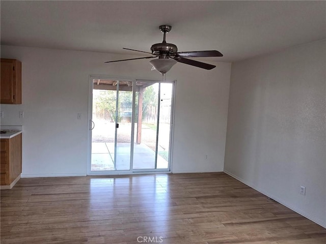 empty room featuring ceiling fan and light hardwood / wood-style flooring