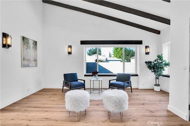 sitting room featuring high vaulted ceiling, light wood-type flooring, and beamed ceiling