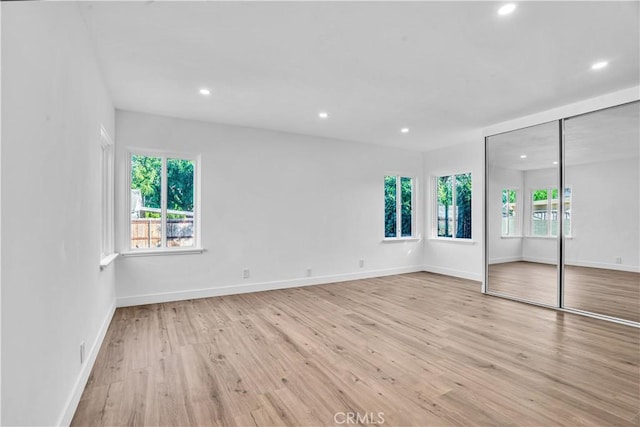 unfurnished bedroom featuring light hardwood / wood-style flooring and a closet