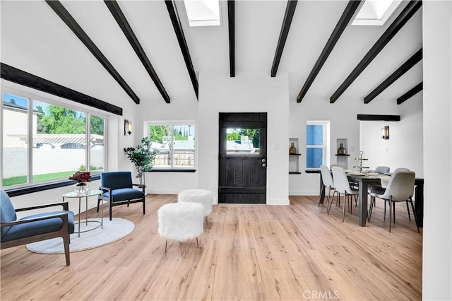 living room featuring high vaulted ceiling, light wood-type flooring, and beamed ceiling