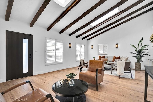 living room featuring high vaulted ceiling, beamed ceiling, and light hardwood / wood-style floors