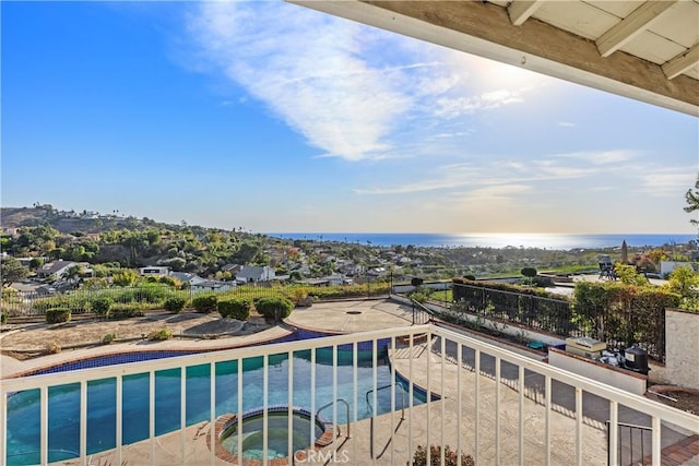 view of pool featuring a water view and an in ground hot tub