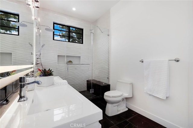 bathroom featuring toilet, tile patterned floors, vanity, and a shower with shower door