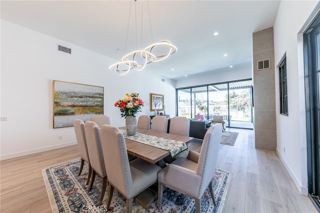 dining area with a chandelier and light hardwood / wood-style flooring