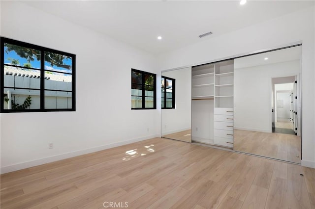 unfurnished bedroom featuring a closet and light wood-type flooring