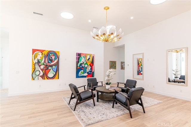 living area featuring a chandelier and light hardwood / wood-style flooring