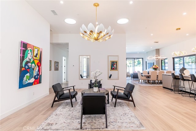 living room featuring light hardwood / wood-style flooring and an inviting chandelier