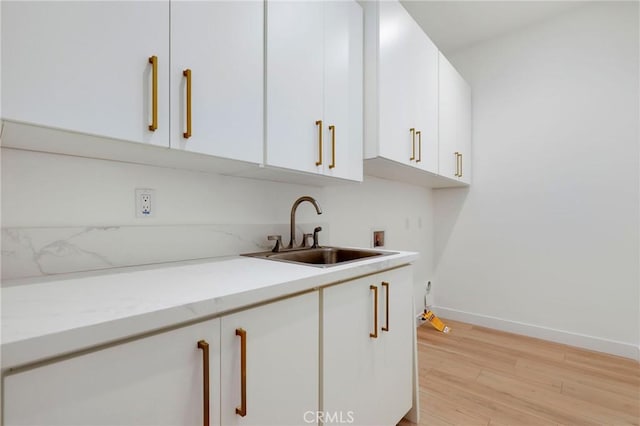 kitchen featuring sink, white cabinetry, and light hardwood / wood-style flooring