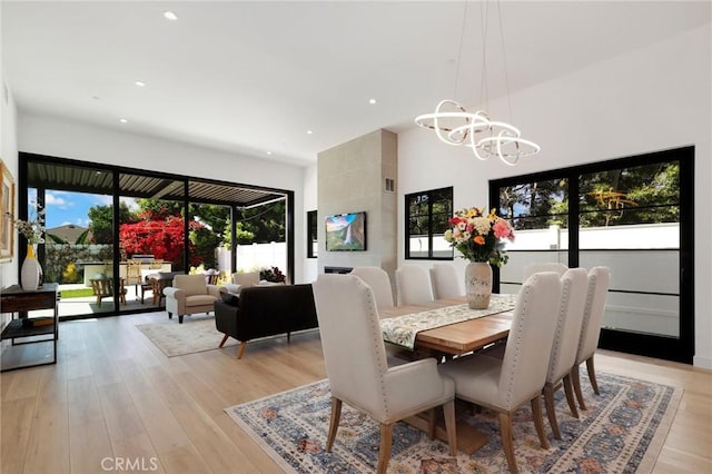 dining room with light wood-type flooring and an inviting chandelier