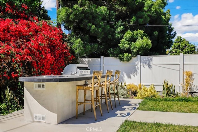 view of patio with a bar, a grill, and area for grilling