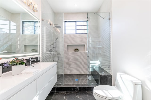 bathroom featuring toilet, a shower with door, and vanity