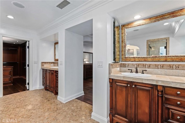 bathroom featuring hardwood / wood-style flooring, backsplash, vanity, and ornamental molding