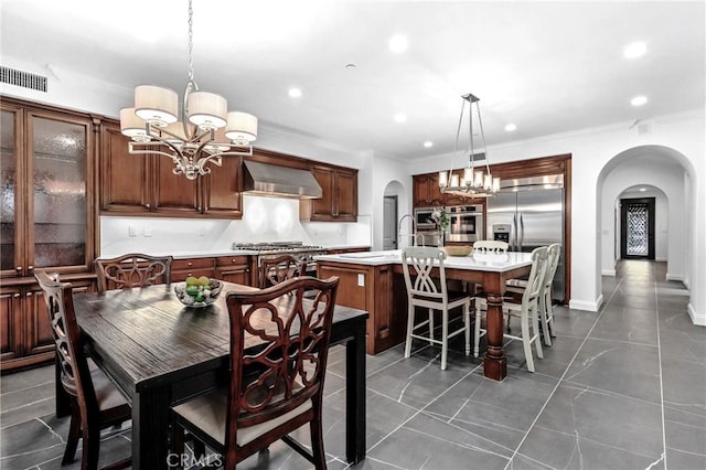 dining room featuring sink, a chandelier, and ornamental molding