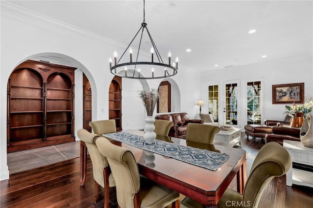 dining room with french doors, an inviting chandelier, dark hardwood / wood-style floors, built in features, and crown molding