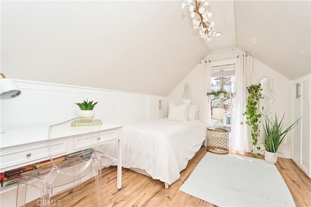 bedroom with vaulted ceiling and light hardwood / wood-style flooring