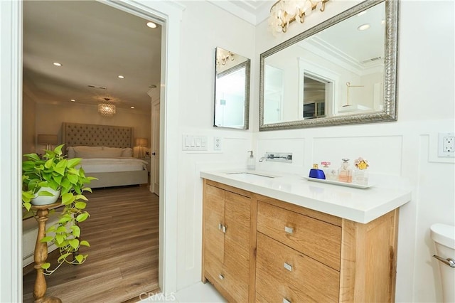 bathroom featuring toilet, crown molding, hardwood / wood-style floors, and vanity