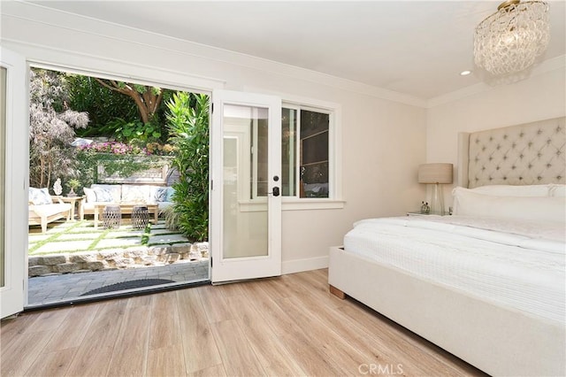 bedroom featuring access to exterior, light hardwood / wood-style floors, and french doors