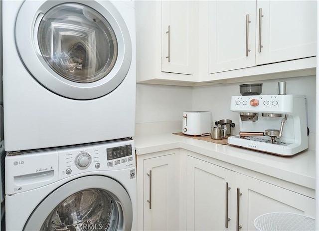 laundry room with stacked washer and dryer and cabinets