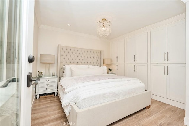 bedroom featuring a closet, crown molding, a chandelier, and light hardwood / wood-style floors