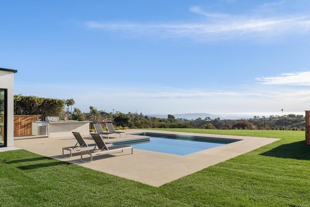 view of pool with a patio area, a lawn, exterior kitchen, and exterior bar