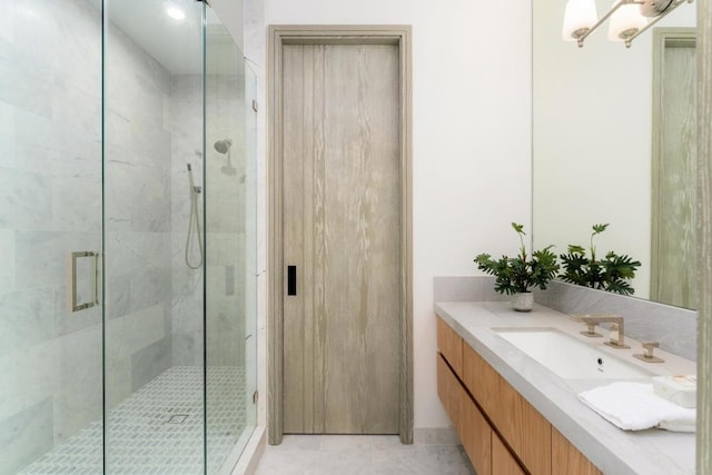 bathroom featuring a shower with door, vanity, and tile patterned flooring