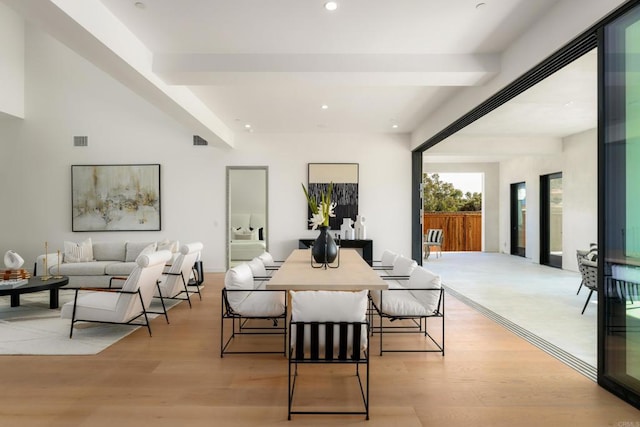 dining room with beam ceiling and light hardwood / wood-style flooring