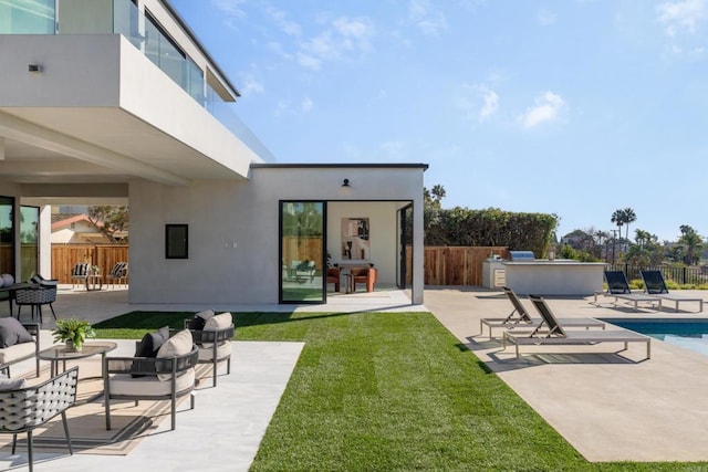 back of property with a fenced in pool, a patio area, and a lawn