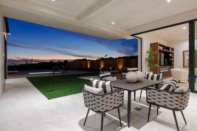 patio terrace at dusk featuring outdoor lounge area and a fenced in pool