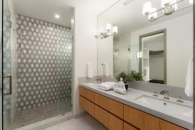 bathroom with a shower with door, vanity, tile patterned floors, and a chandelier