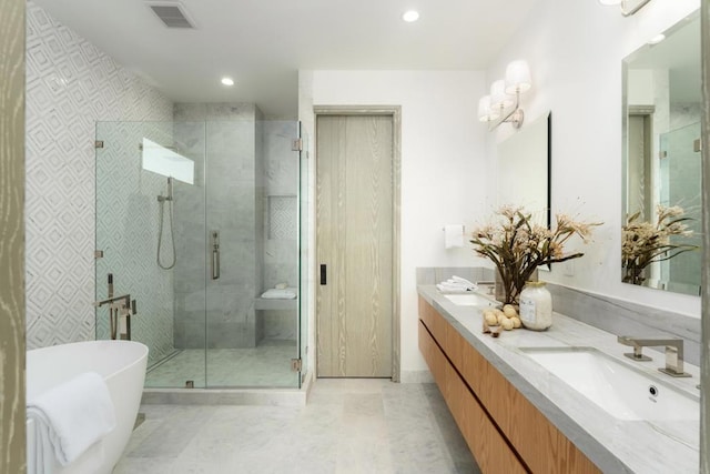 bathroom with vanity and shower with separate bathtub