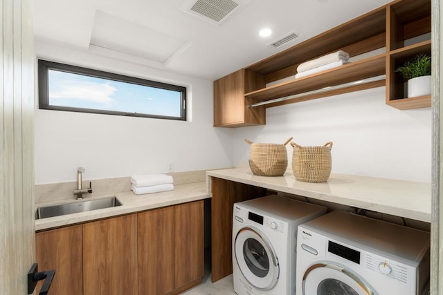 washroom featuring cabinets, separate washer and dryer, and sink