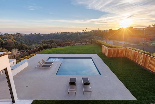 pool at dusk featuring a yard