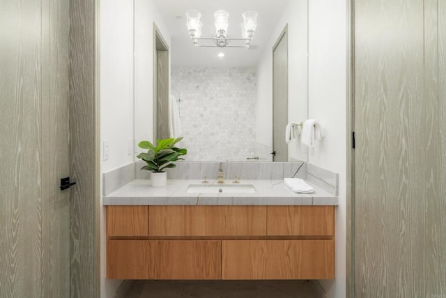 bathroom featuring vanity, a notable chandelier, and walk in shower