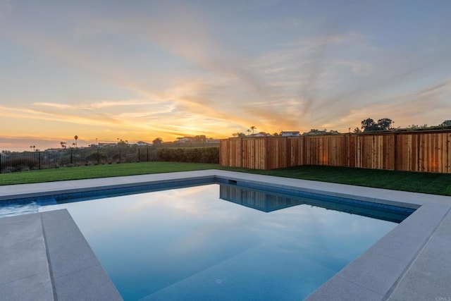 pool at dusk with a lawn