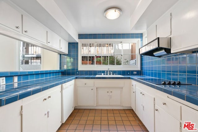 kitchen with tile countertops, white cabinets, and tasteful backsplash