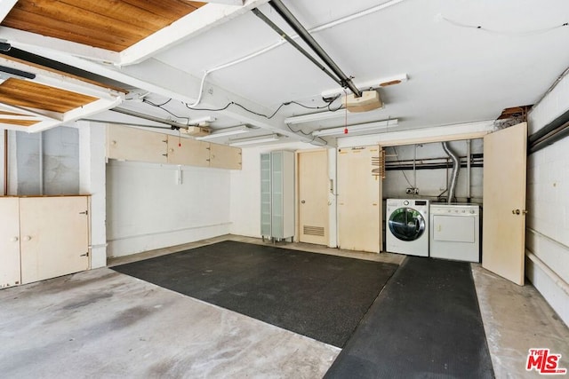 garage with a garage door opener and separate washer and dryer