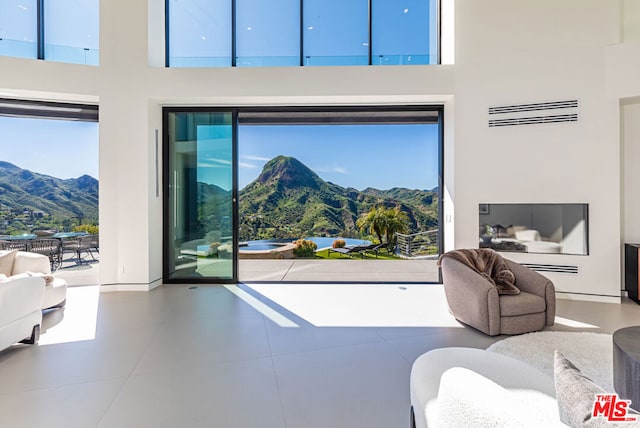 tiled living room with a mountain view and a towering ceiling