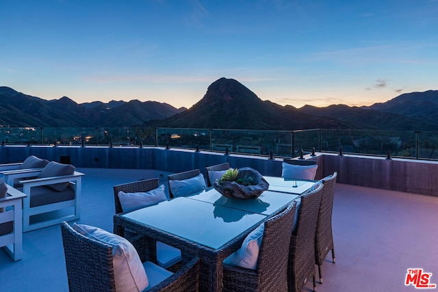 patio terrace at dusk featuring a mountain view