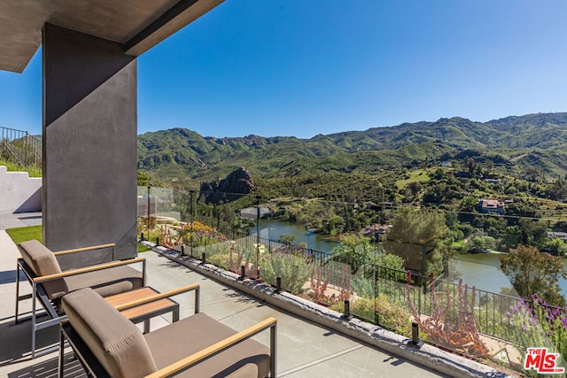 exterior space featuring a balcony and a water and mountain view