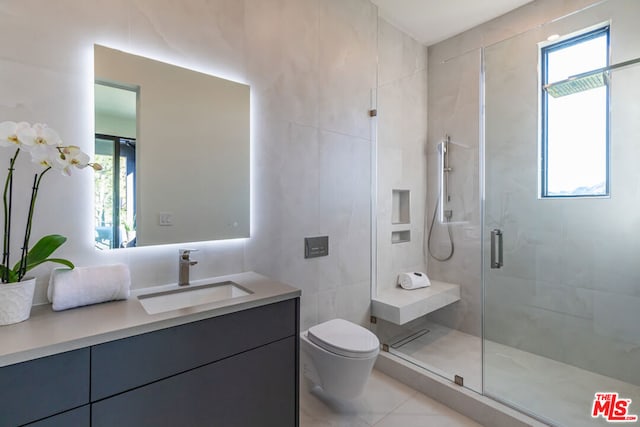 bathroom with toilet, vanity, tile walls, tile patterned flooring, and an enclosed shower