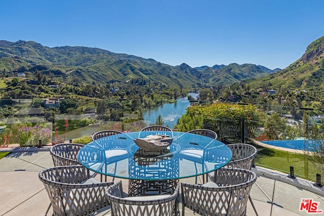 view of patio with a water and mountain view