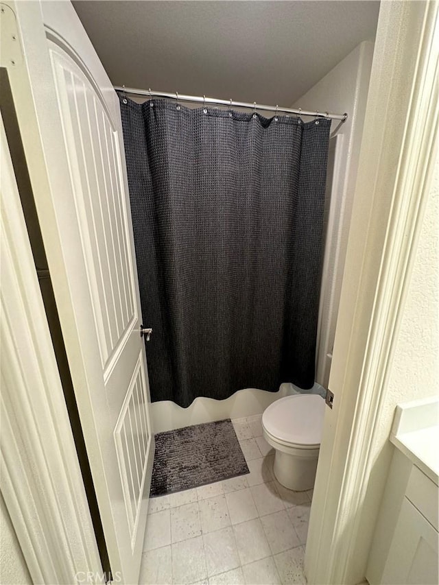 bathroom with curtained shower and toilet