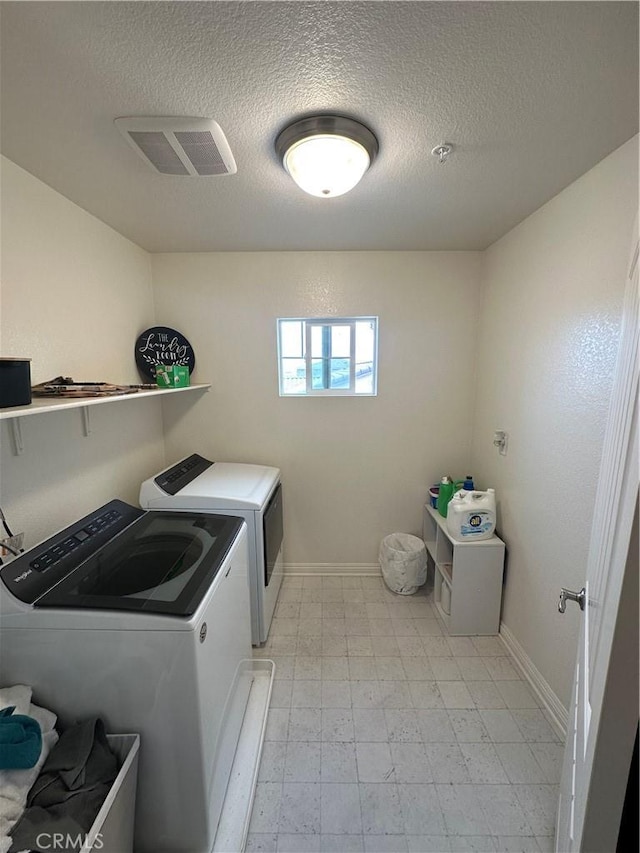 laundry room featuring washer and dryer and a textured ceiling