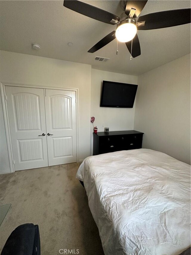 bedroom with ceiling fan, a closet, and carpet