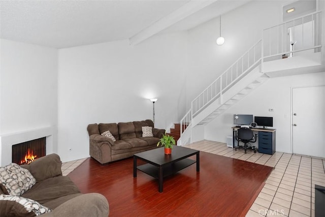 tiled living room featuring vaulted ceiling with beams