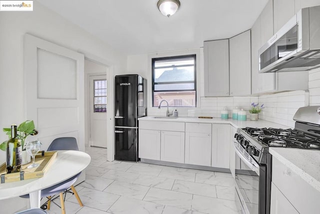 kitchen featuring white cabinets, backsplash, sink, and stainless steel appliances