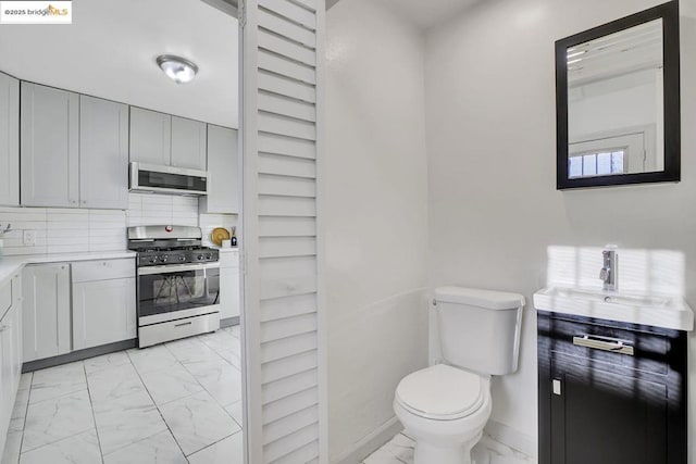 bathroom with decorative backsplash, sink, and toilet