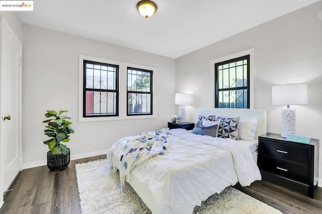 bedroom featuring dark wood-type flooring and multiple windows