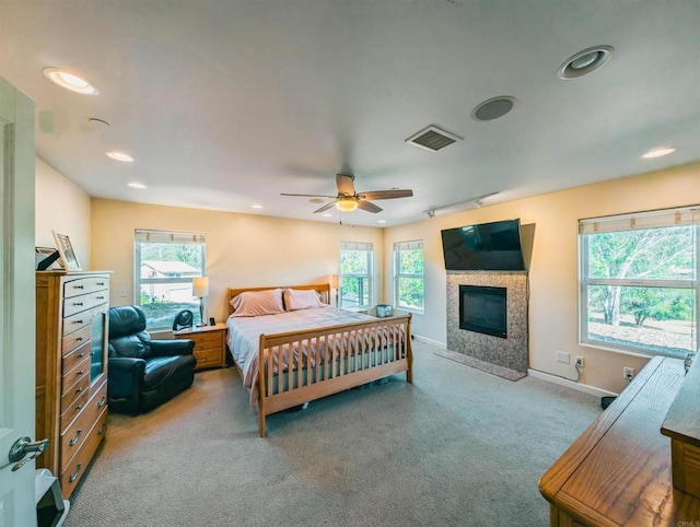 bedroom with multiple windows, light carpet, and ceiling fan