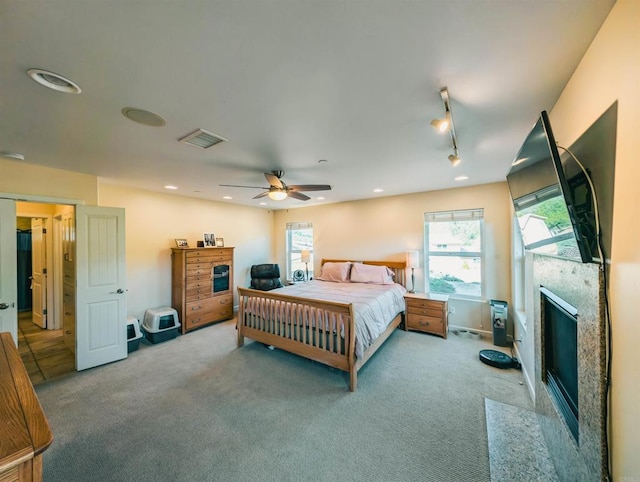 carpeted bedroom with track lighting and ceiling fan